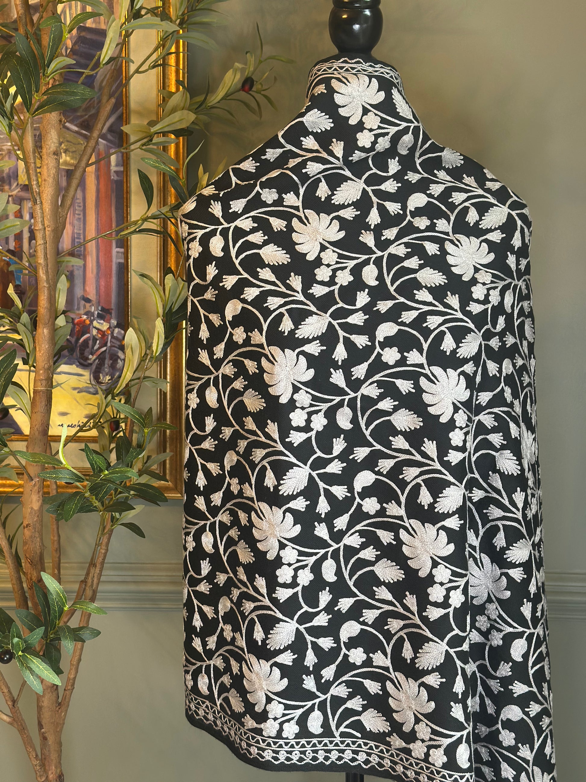 Black and white floral patterned shawl on a mannequin against a neutral background
