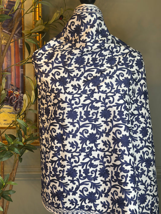 white wrap with blue floral pattern on a mannequin against a neutral background.