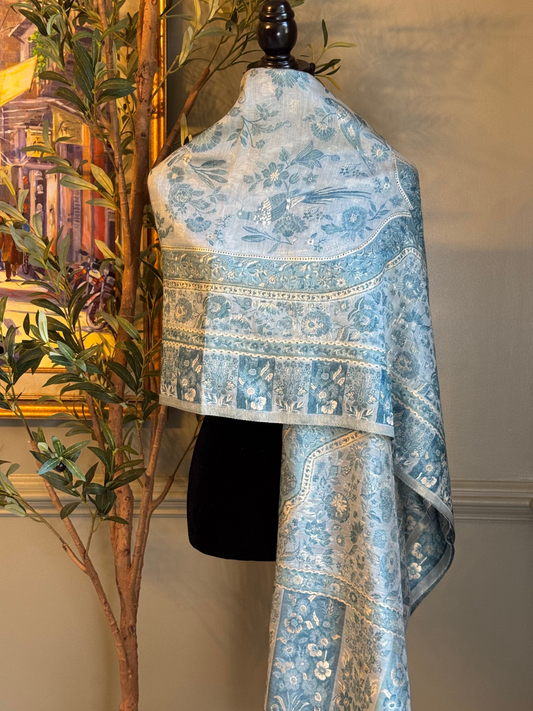 Blue floral patterned fabric on a mannequin against a neutral wall with a plant in the background