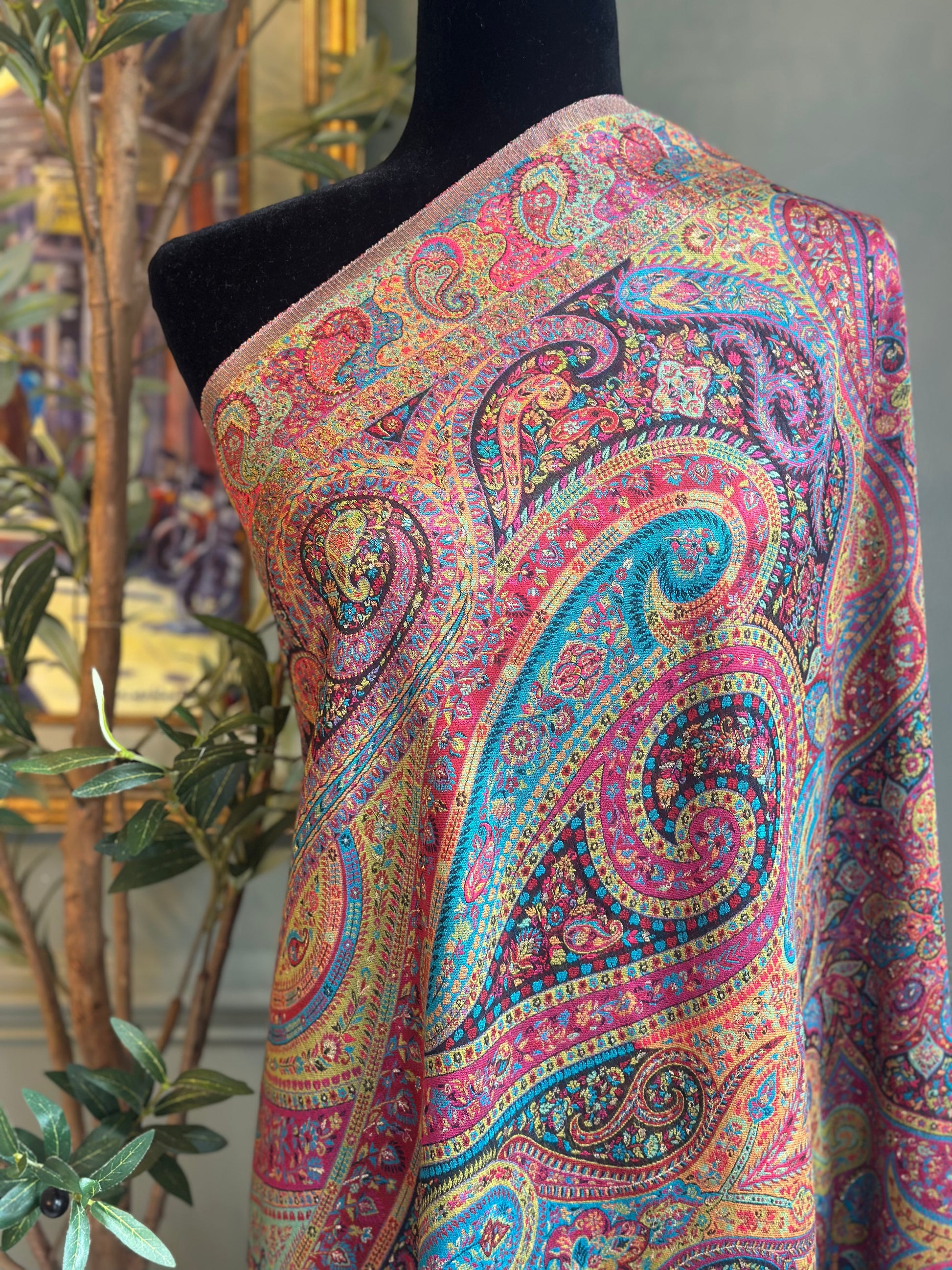 Colorful paisley-patterned fabric on a mannequin with an indoor background