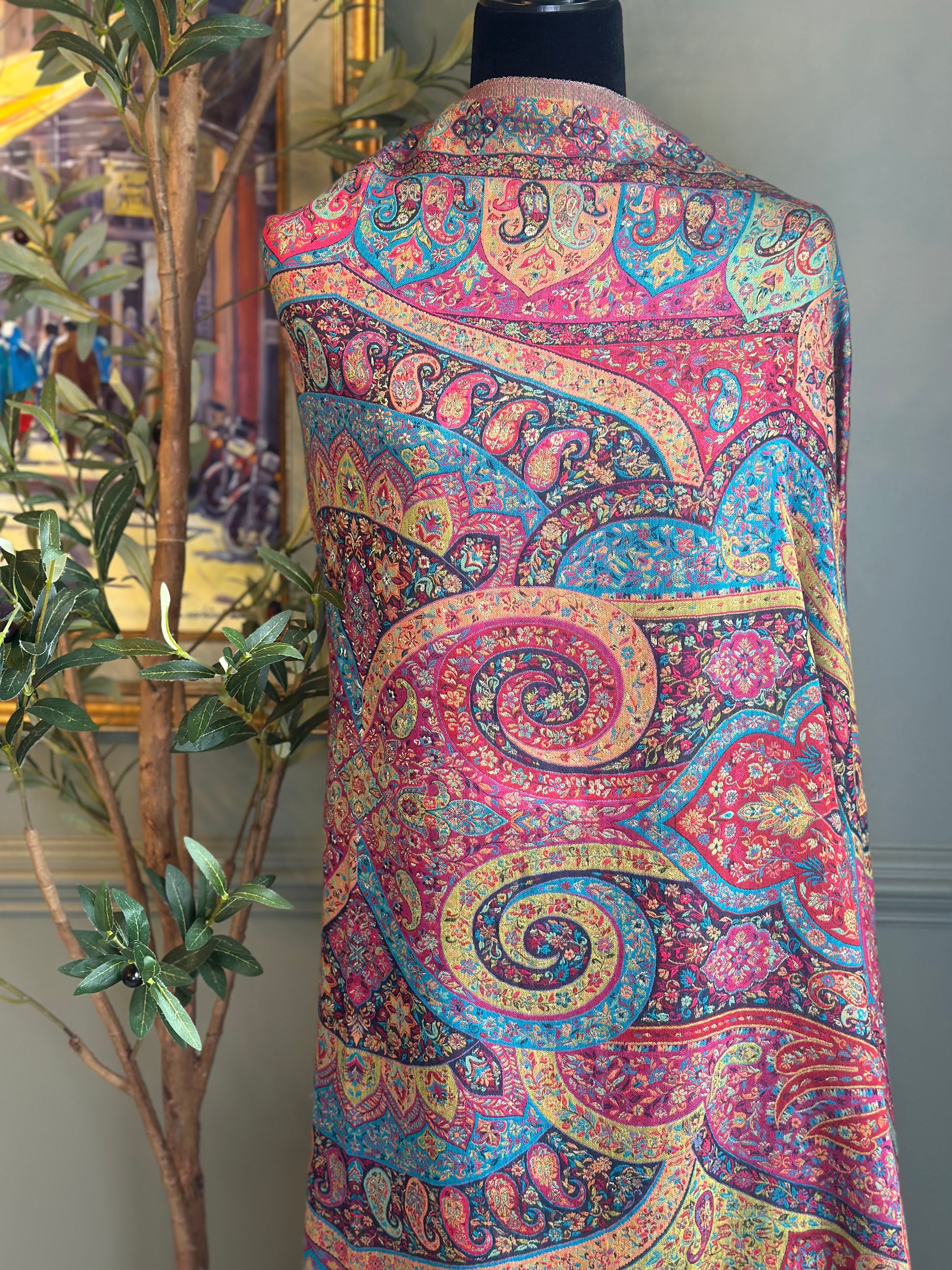 Colorful paisley-patterned garment on a mannequin against a neutral background