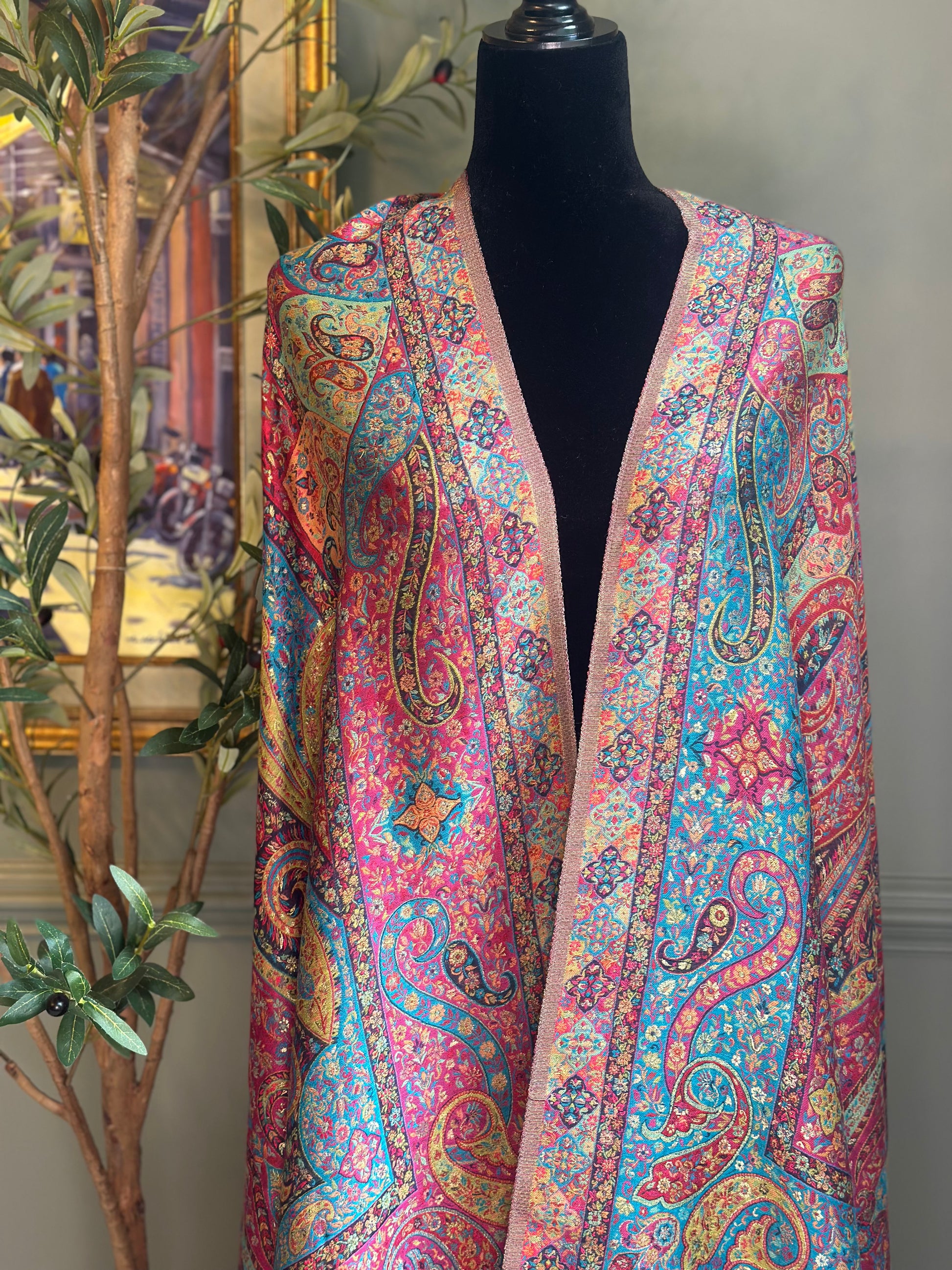 Colorful paisley-patterned scarf on a mannequin against a neutral background