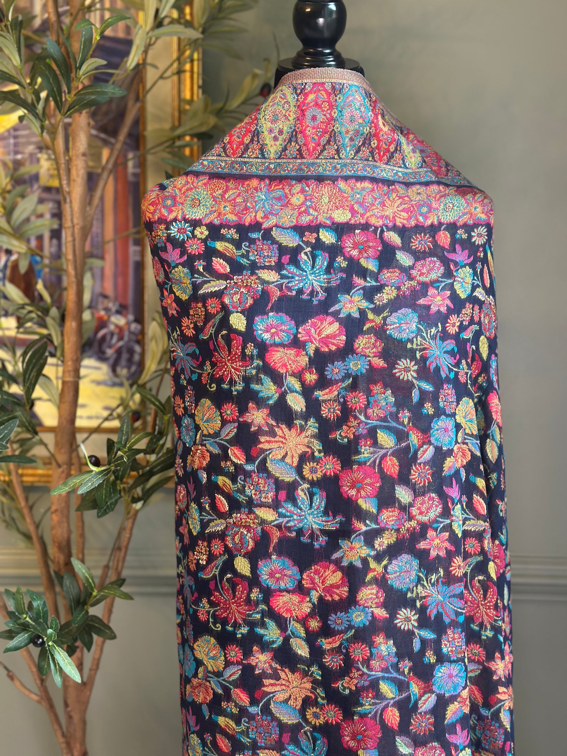 Mannequin wearing a colorful floral dress with a dark background