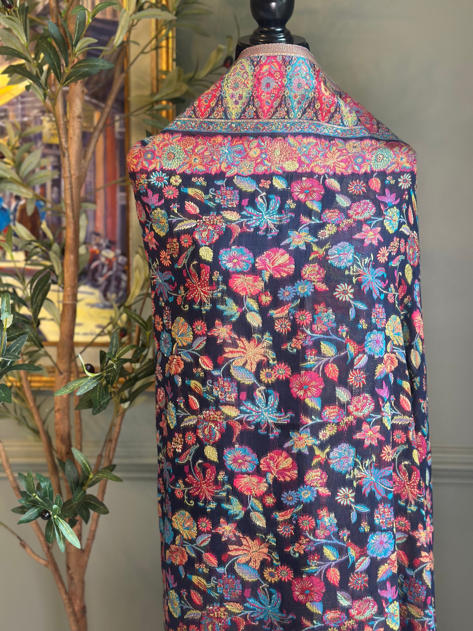 Colorful floral-patterned fabric draped over a mannequin against a neutral background.