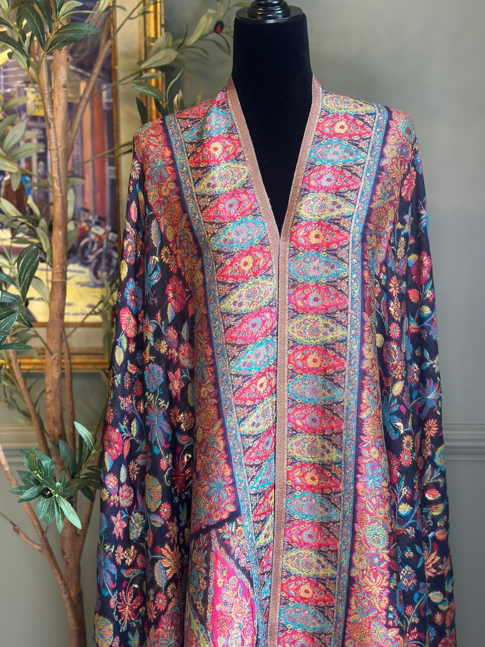 Colorful patterned scarf on a mannequin against a neutral background
