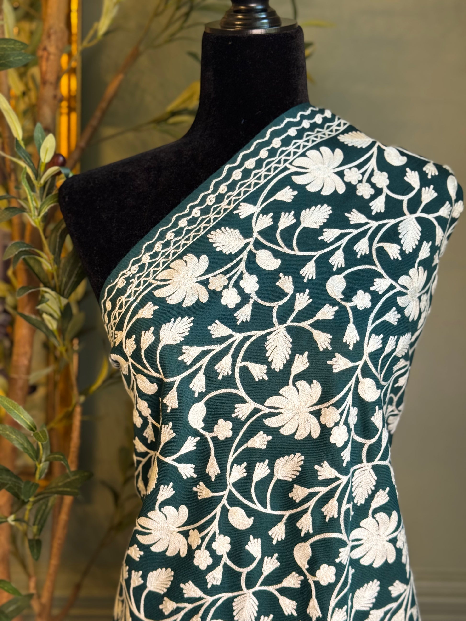 Mannequin wearing a dark green fabric with white floral patterns