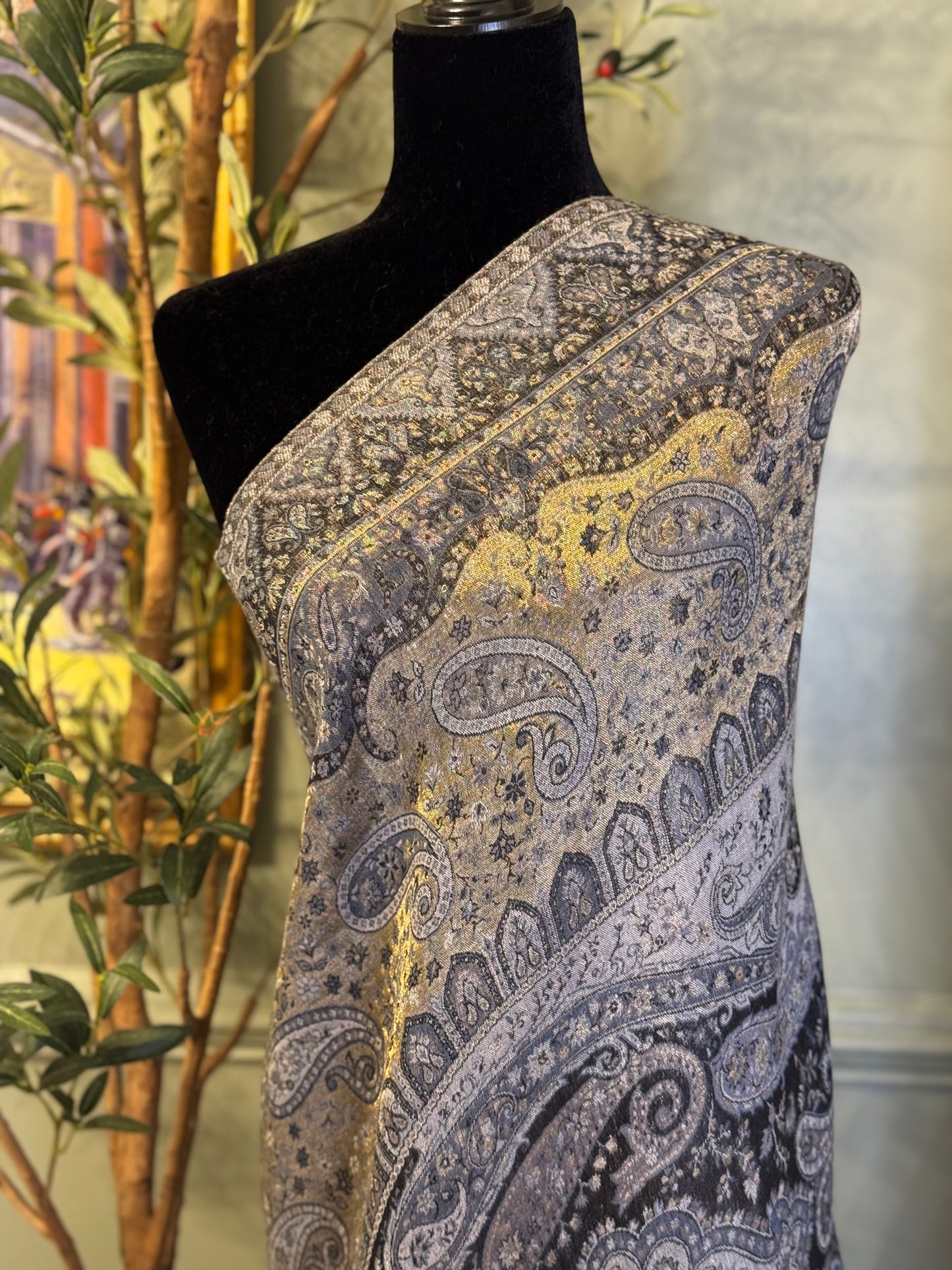 Mannequin wearing a patterned fabric with a paisley design in gray, blue, and yellow.