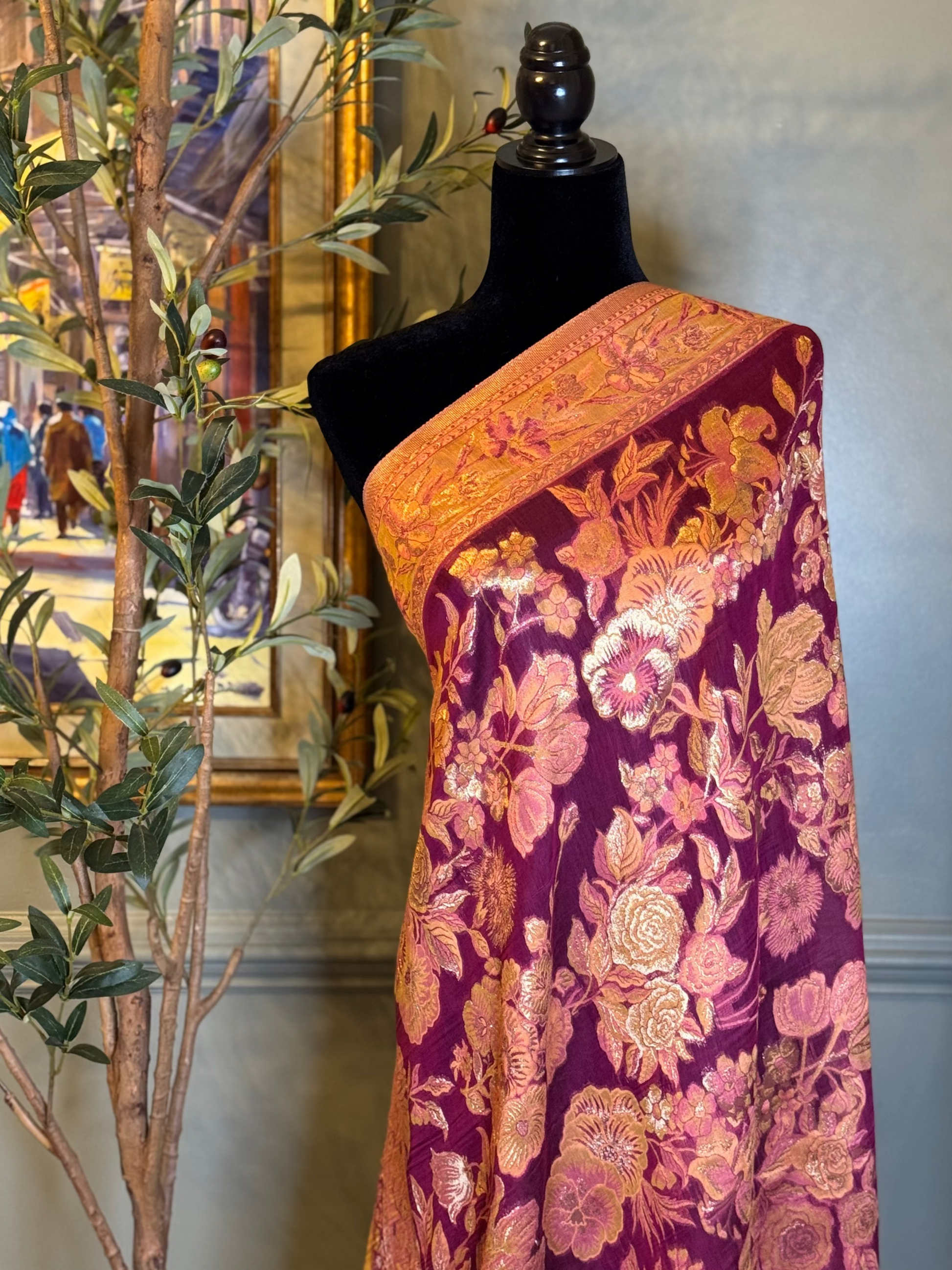 Mannequin wearing a floral patterned fabric with a pink base color, set against a neutral background.